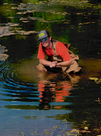 a man crouching in the water with a frisbee